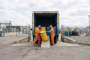 Специалист в защитной одежде проводит профессиональный вывоз химических отходов с территории медицинского центра